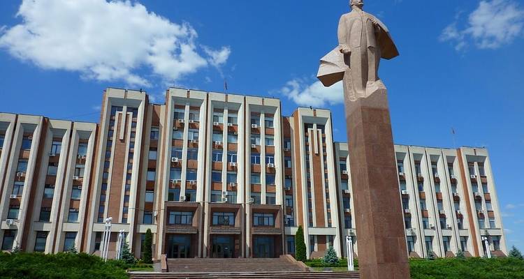Leninstandbeeld dat domineert op het plein voor het parlementsgebouw van Tiraspol op een zonnige dag.