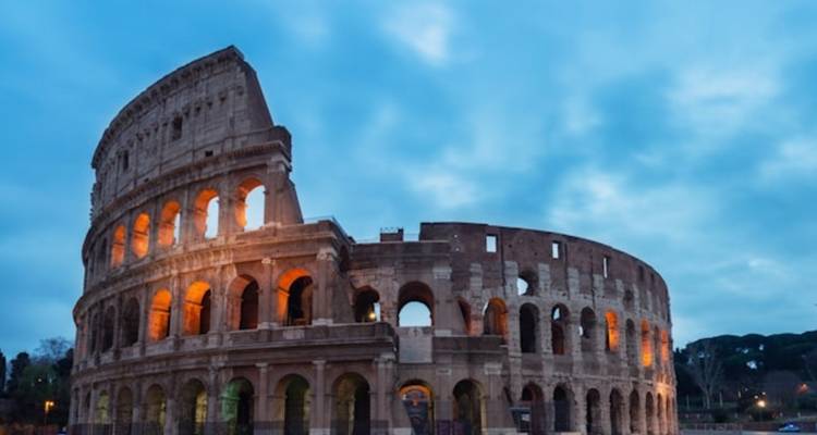 Schemering afbeelding van Romes verlichte Colosseum die tegen een dramatische blauwe lucht afsteekt.