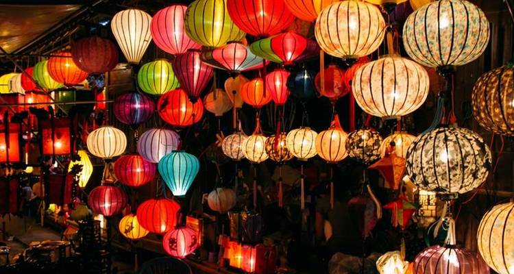 Puesto de faroles vibrantes brillando con luces multicolores en el mercado nocturno de Hoi An.