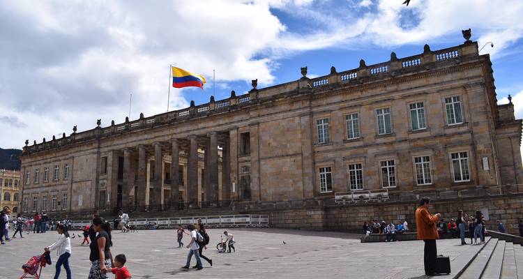 Edificio del Capitolio Nacional de Colombia en la Plaza de Bolívar de Bogotá con gente local y palomas merodeando por ahí.