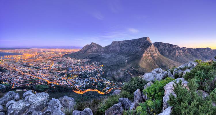 Panoramisch uitzicht bij schemering vanaf Table Mountain over de stadslichten van Kaapstad en de vlakke bergTop