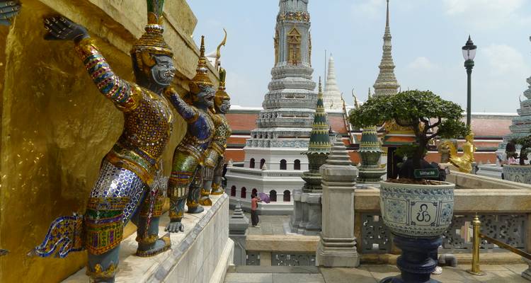 Les gardiens démons en mosaïque colorée soutenant la terrasse du chedi doré au sein du complexe du Grand Palais de Bangkok.