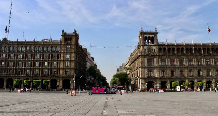 Weitläufiger Blick auf den Zócalo-Platz, flankiert von historischen Regierungsgebäuden und riesigen XM-Buchstaben