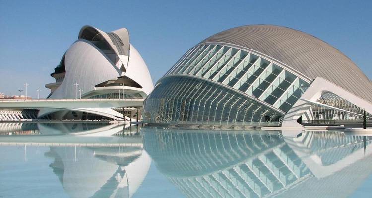 Futuristic white and glass buildings of the City of Arts and Sciences reflecting perfectly in a still pool