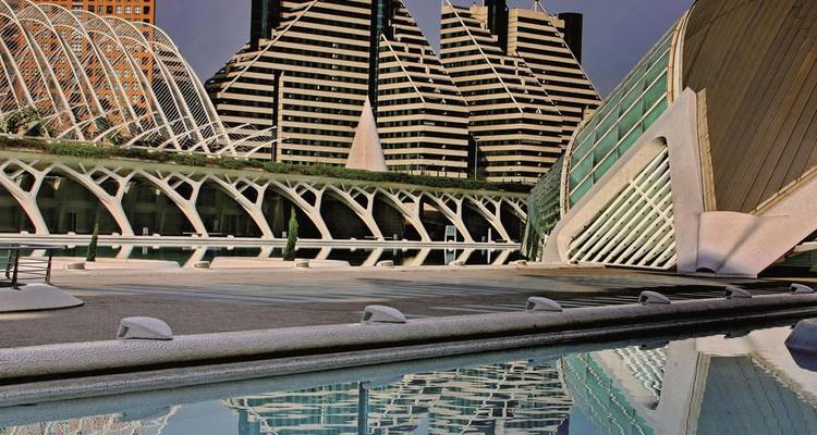 Modern architectural structures and reflections at the City of Arts and Sciences complex with still water in foreground