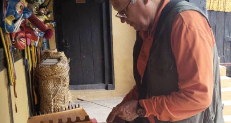 Oudere reiziger bekijkt traditionele instrumenten en handwerkstukken in een culturele tentoonstelling.