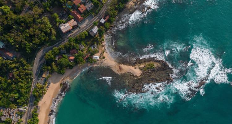 Toma de dron de una península rocosa y olas turquesas chocando a lo largo de la costa sur de Sri Lanka.