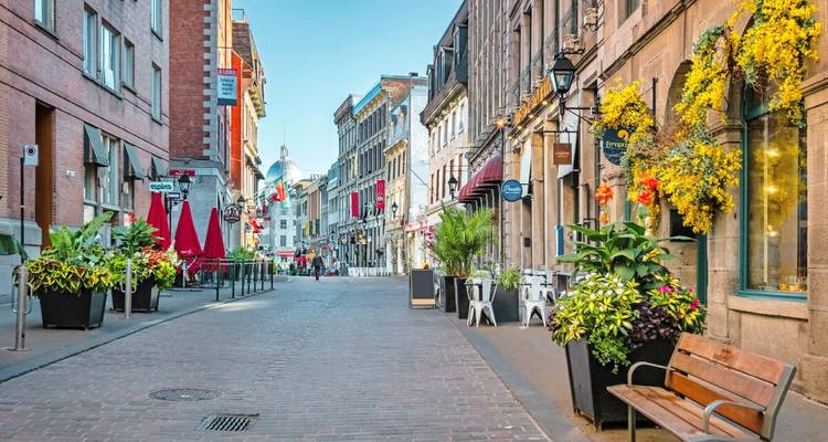 Charmante Kopfsteinpflasterstraße mit Cafés, Blumenkästen und historischen Steingebäuden in Altmontreal