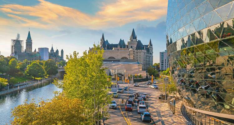 Skyline von Ottawa mit Parlamentsgebäuden, Château Laurier und Verkehr entlang des Kanals unter einem farbenfrohen Abendhimmel