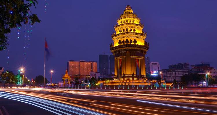 El Monumento a la Independencia se ilumina hermosamente por la noche con los rastros dinámicos de luz del tráfico que pasa.