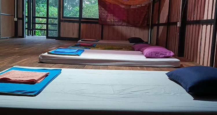 Simple dormitory with thin mattresses laid on polished wooden floor