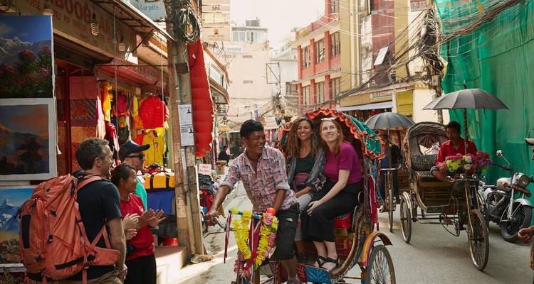 Colourful rickshaw ride through a bustling Kathmandu alley filled with shops and pedestrians.