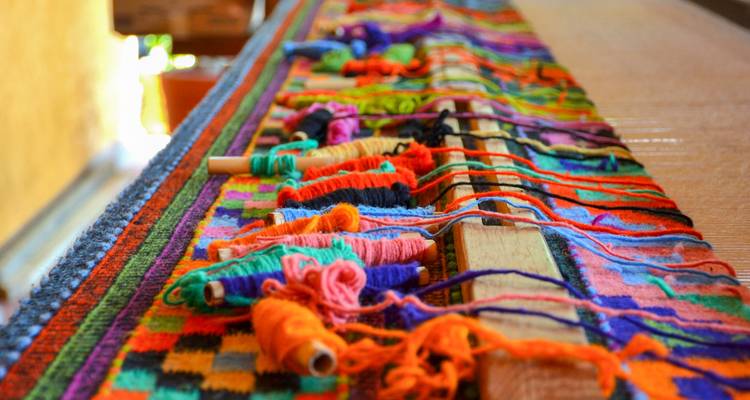 Fils de laine colorés sur un métier à tisser traditionnel dans un atelier mexicain
