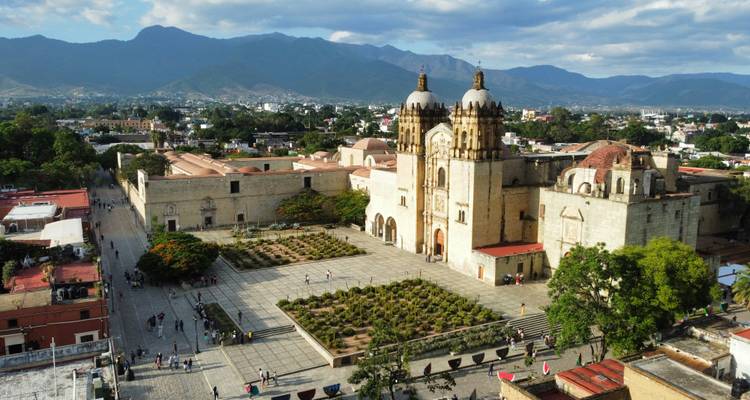 Luftaufnahme der Kathedrale von Santo Domingo und ihres Platzes mit Bergen, die die Stadt Oaxaca umgeben.
