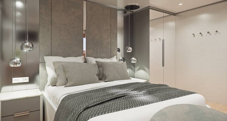 Camarote moderno de crucero con cabecera texturizada, lámparas colgantes y decoración neutral.