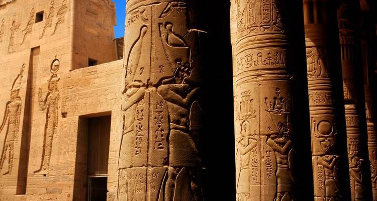 Zandkleurige tempelkolommen rijk versierd met oude Egyptische hiërogliefen in warm licht