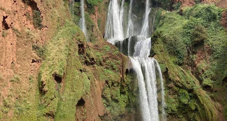 Segmentos altos y estrechos de la cascada Ouzoud cayendo en cascada sobre acantilados cubiertos de verde