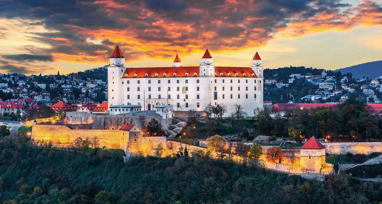 Bratislava Castle glowing at sunset above the city and Danube River