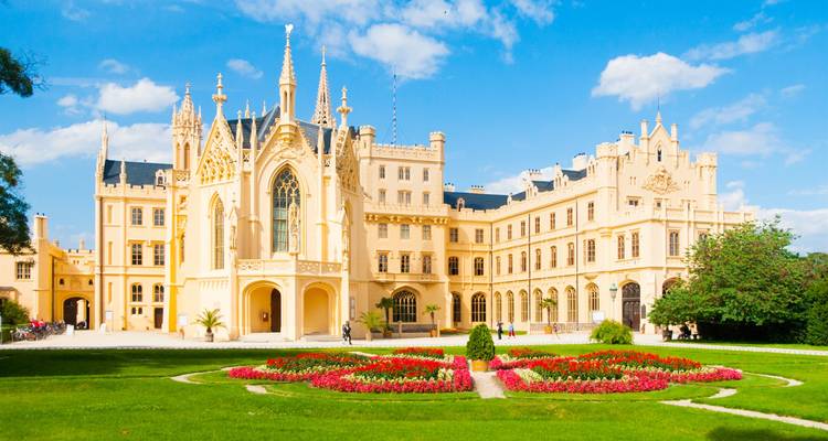 Bright summer view of Lednice Chateau with manicured flowerbeds and blue sky