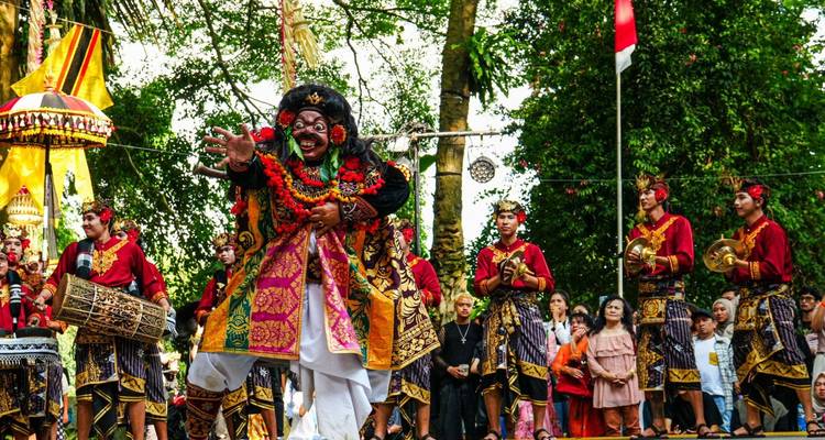 Vibrant Balinese performers in ornate costumes dance during a colorful cultural festival.