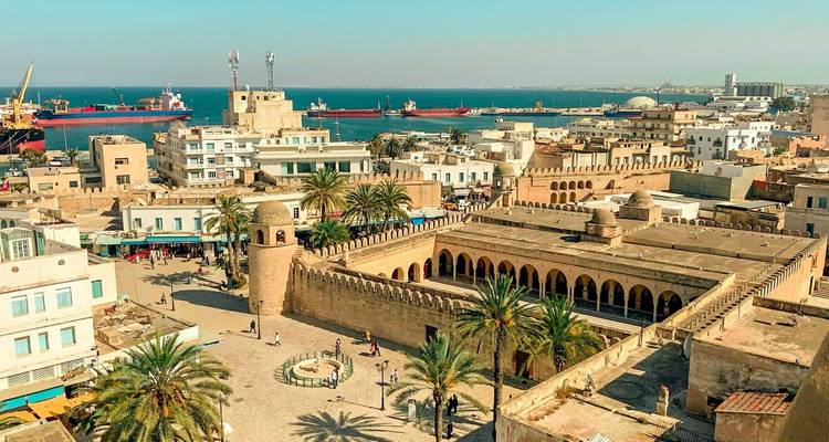 Vue aérienne de la Médina de Sousse et des remparts avec le port et la Mer Méditerranée au-delà.