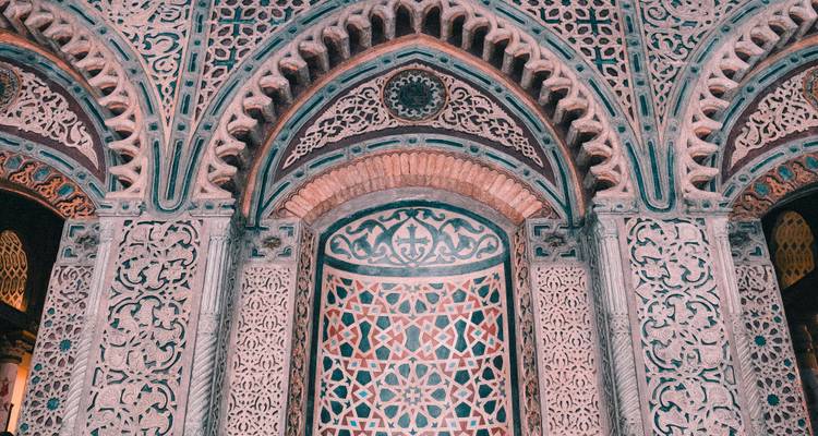 Portail islamique finement ciselé aux motifs géométriques colorés en carrelage au Caire.