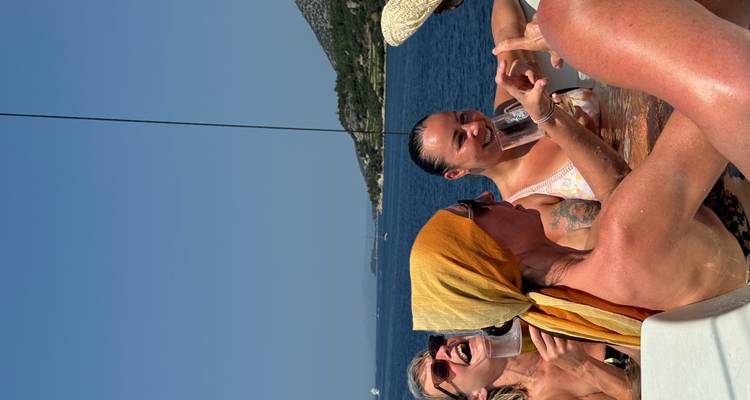 Vrienden delen grappen in een jacuzzi op een jacht met de Kroatische kustlijn op de achtergrond.