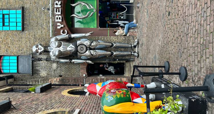 Voorkant van de Cyberdog-winkel met een imposante zilveren robotstandbeeld en een kleurrijke paardenbeeldhouwwerk.