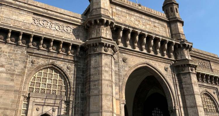 Arco de piedra y torres del monumento Puerta de India iluminados por la luz del sol de la tarde.