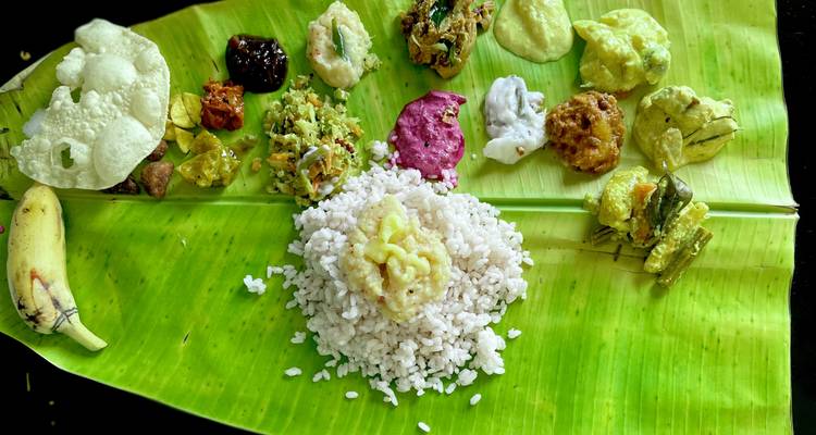 Comida tradicional de Kerala Sadya servida en una hoja de plátano con arroz, curries y varios acompañamientos.
