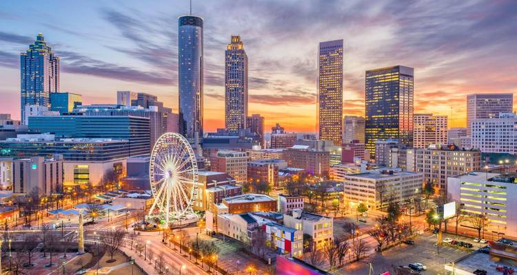 Sunrise over Atlanta skyline with SkyView Ferris wheel and illuminated downtown towers.