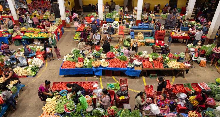 Vue générale dynamique d'un marché de produits frais animé avec des fruits et légumes colorés.