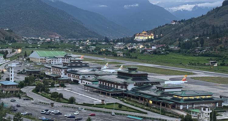Groothoekopname tijdens schemering van de startbaan van Paro Airport omgeven door bergen