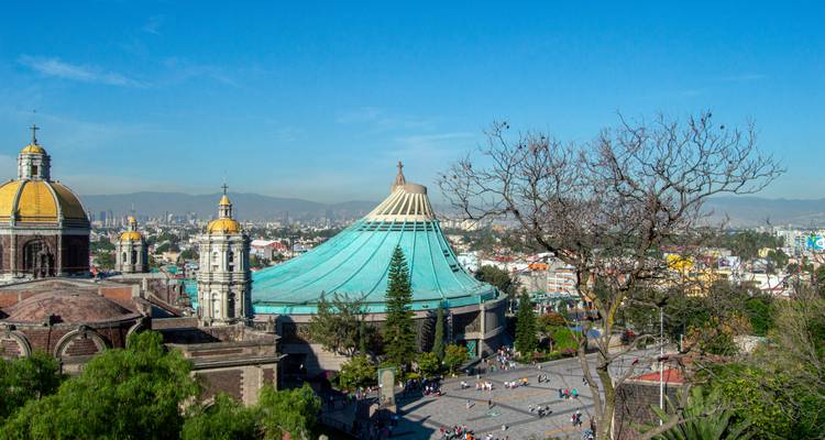 Vue panoramique du complexe de la Basilique Notre-Dame de Guadalupe avec sa moderne église aux toits bleu-vert et ses dômes environnants.