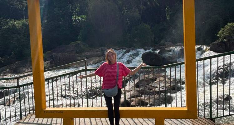 Traveler framed in a large yellow photo frame before a rushing waterfall
