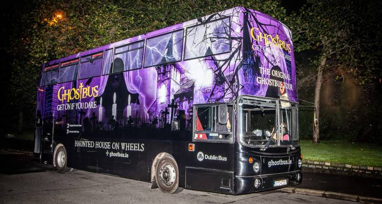 Purple-black Ghostbus parked at night offering a haunted sightseeing tour in Dublin