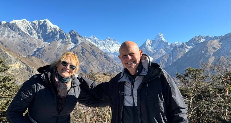 Gelukkig stel gekleed in winterkleding met een adembenemend Himalaya-panorama achter hen.