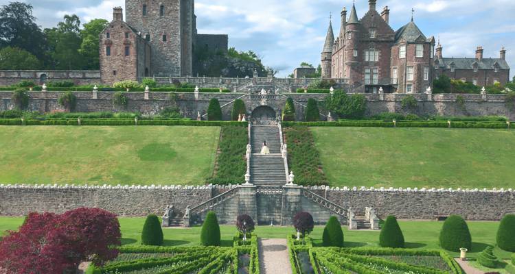 Des jardins en terrasses élégants et de grands escaliers mènent vers un manoir écossais historique.