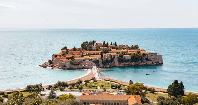 Iconisch eilandje Sveti Stefan verbonden met het vasteland door een smalle dam te midden van turkooiskleurig water.