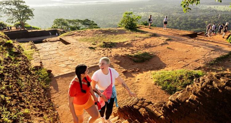 Les voyageurs gravissent le rocher en terrasses de Sigiriya, profitant de vues panoramiques sur la jungle baignées par le soleil de l'après-midi.