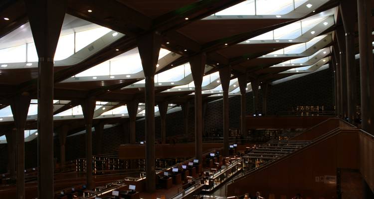 Intérieur moderne de la Bibliotheca Alexandrina avec colonnes inclinées et panneaux de toit en verre.
