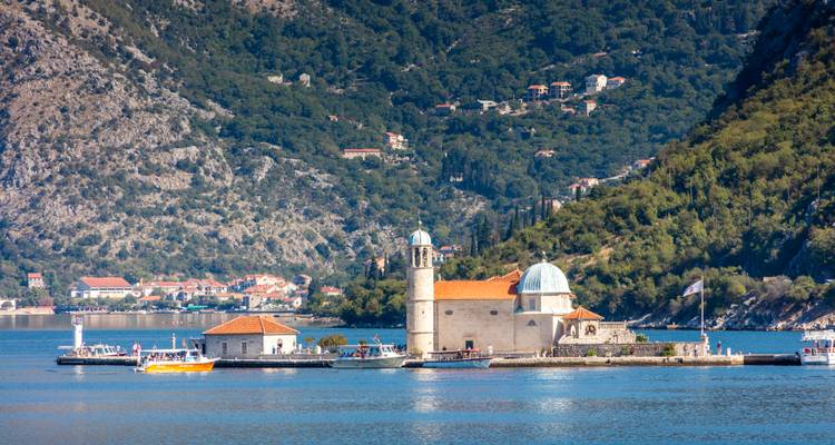 L'église insulaire de Notre-Dame des Rochers repose sereinement dans la Baie de Kotor, face aux pentes boisées.