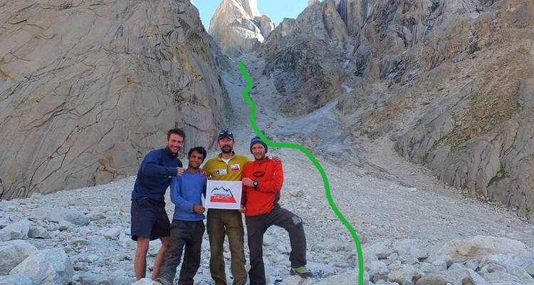 Climbers pose in front of a steep couloir with a bright green route line drawn over the photo.