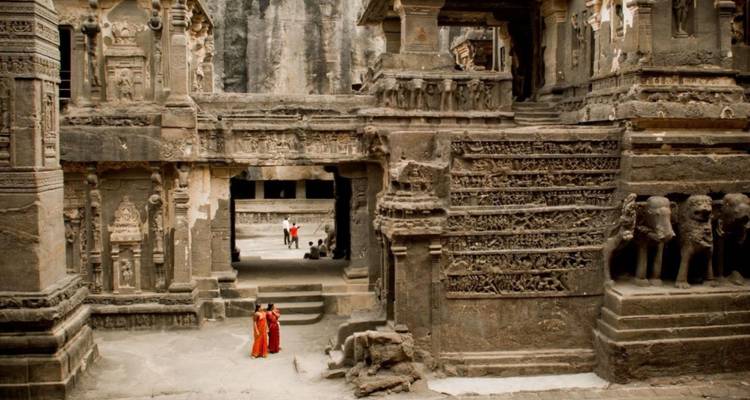 Bezoekers verkennen de monumentale stenen architectuur van Ellora's Kailasa-tempel.