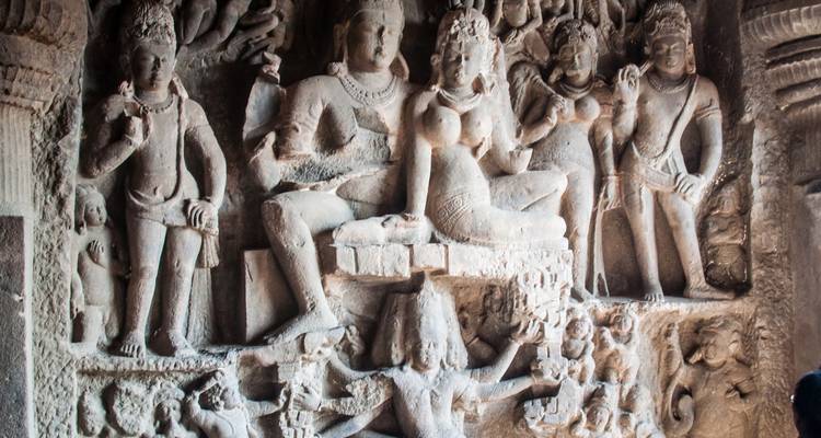Gedetailleerde stenen reliëfsculptuur met afbeeldingen van goden in de Ajanta Grotten.