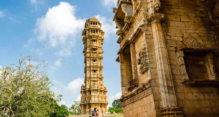 De sierlijke Victory Tower verheft zich naast oude stenen tempels bij het fort van Chittorgarh.