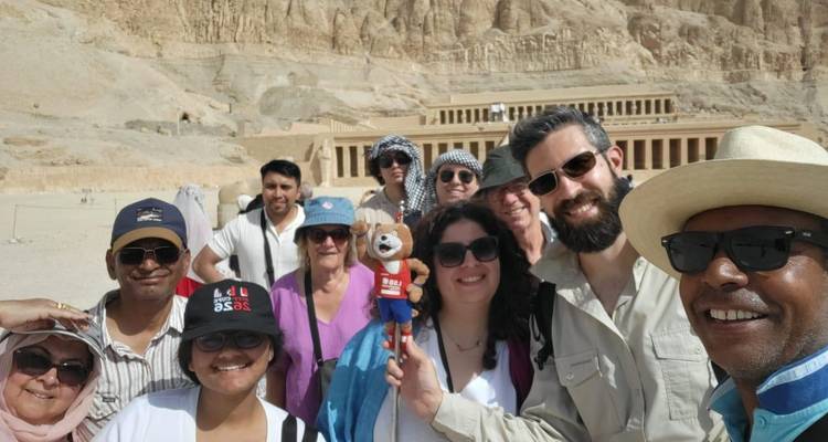 Selfie de voyageurs devant le temple spectaculaire d'Hatshepsut à flanc de falaise à Deir el-Bahari.