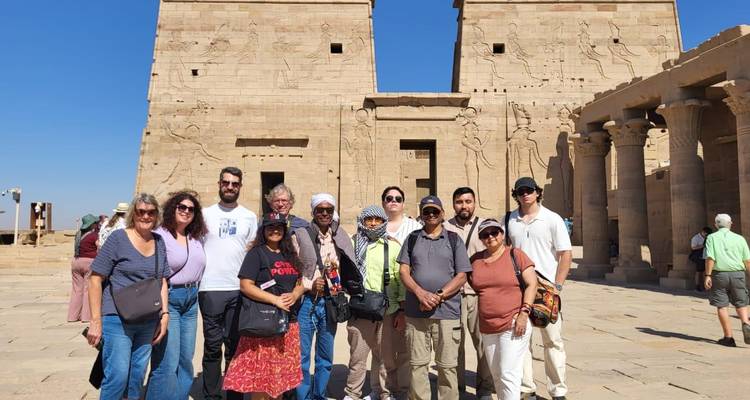 Les voyageurs se rassemblent devant la cour d'entrée du Temple de Philae pour une photo de groupe ensoleillée.