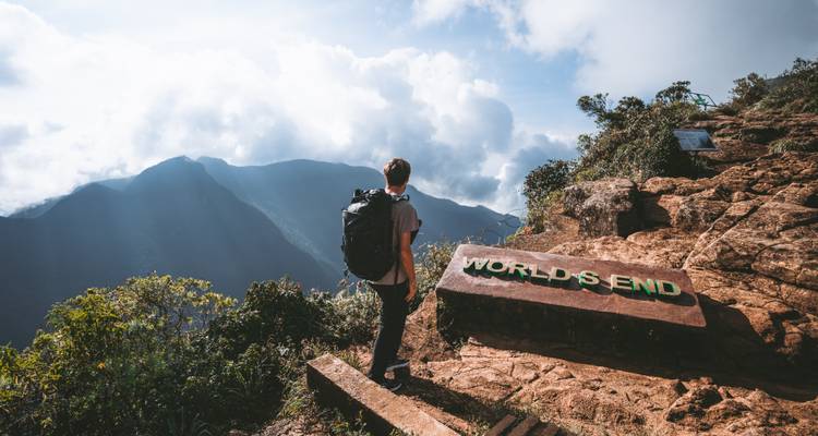 Hiker with backpack standing at World's End viewpoint overlooking mountains
