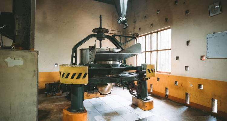 Old industrial tea processing machine inside dimly lit factory room